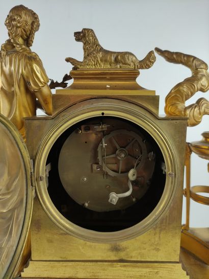 null An ormolu and chased clock decorated with a vestal and her dog leaning on a...