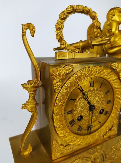 null A gilt bronze and chased clock decorated with Cupid and his attributes. The...