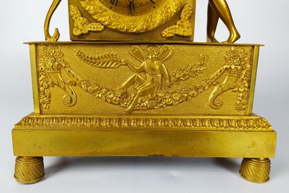  PENDULE en bronze doré et ciselé à décor de Cupidon avec ses attributs. Le cadran...