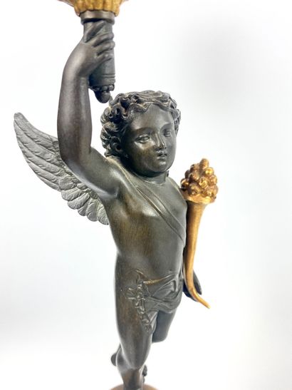 null PAIRE DE CANDELABRES en bronze doré et patiné à décor d'angelots retenant trois...