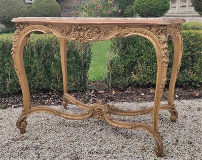 null Gilded wood table with mouldings and carvings of foliage, resting on four curved...