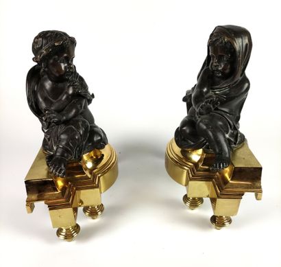 null PAIR OF CHENETS in patinated and gilded bronze decorated with a couple of putti...