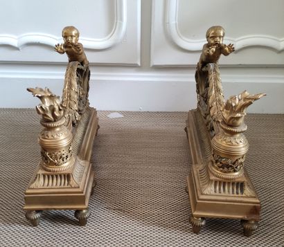 null PAIR OF CHENETS in gilded and chased bronze decorated with two putti warming...