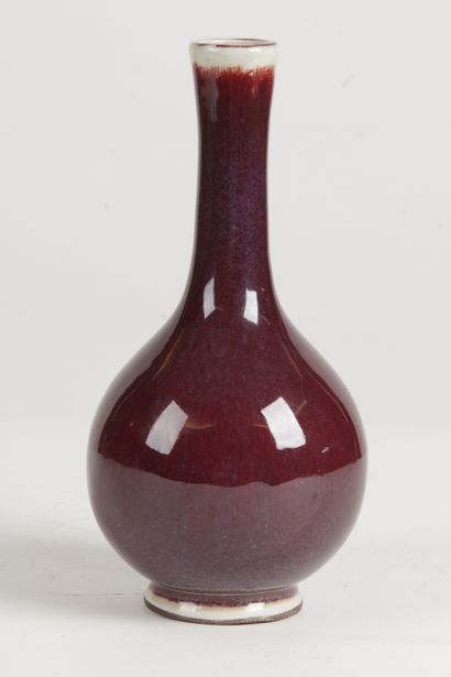 null China, 20th century Oxblood enameled porcelain bottle vase on a slightly celadon...