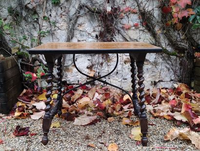A stained wood writing table with four twisted...