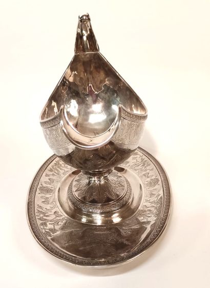 null A silver HELMET SAUCIERE on its frame, richly chased and engraved with foliage,...
