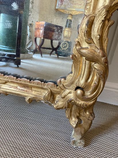 null Large gilded wood MIRROR with foliage decoration, the pediment decorated with...