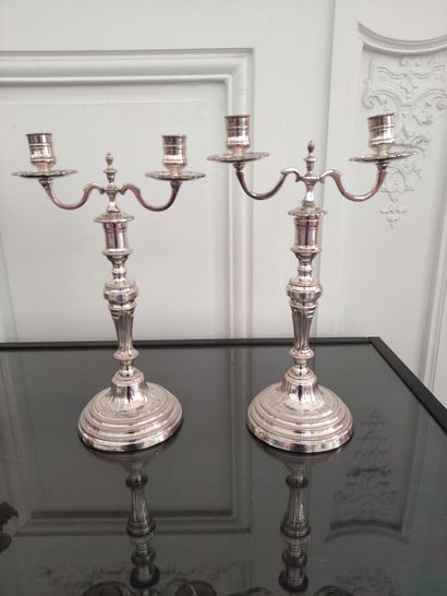 null A Pair of silver plated candlesticks with two arms of lights on a central moulded...