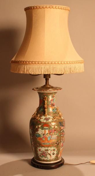 CHINE Lampe en porcelaine de Canton à décor de scènes de palais dans des réserves....