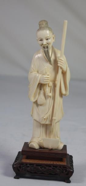 CHINE STATUETTE en ivoire sculpté et patiné représentant un sage en costume traditionnel...