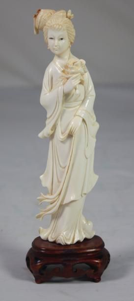 CHINE STATUETTE en ivoire sculpté et patiné représentant une jeune femme tenant une...
