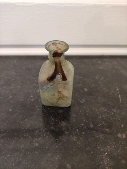 null Bottle with cubic body and handle with poucier. Greenish and partially iridescent...