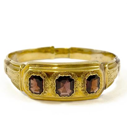 null BRACELET decorated with a chiseled design of interlacing holding three garnets....