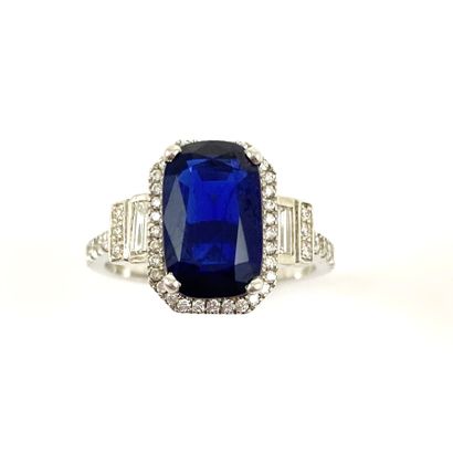 null RING holding a cushion sapphire of 3.23 carats in a setting of brilliant-cut...