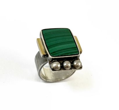 null JEAN DESPRÉS RING adorned with a malachite plate supported by two rectangles...