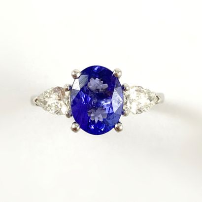 null RING holding a 2.56 carats tanzanite with two pear diamonds. Mounted in 18K...
