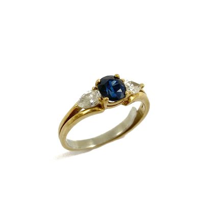 null RING holding a sapphire with two pear diamonds. Double-body setting in 18K yellow...