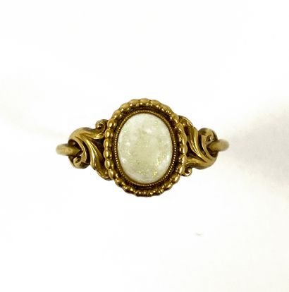 null RING decorated with a cabochon opal in a circle of beads. Mounted in 18K yellow...