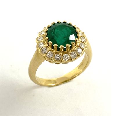 null RING holding a round emerald of approximately 2.5 carat in a surround of brilliant-cut...