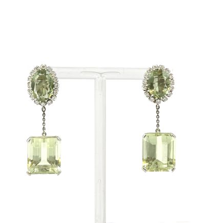 null PAIR OF EARRINGS with an oval scapolite in a circle of brilliant-cut diamonds...