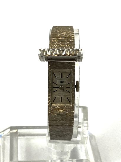 null WATCH holding a textured bracelet with a surround of brilliant cut diamonds....