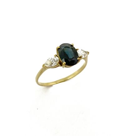 null RING holding an oval sapphire with two pear-shaped diamonds. Mounted in 18K...