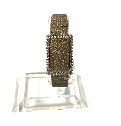 null WATCH holding a textured bracelet with a surround of brilliant cut diamonds....