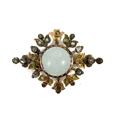 A round cabochon opal in a frame with a plant...