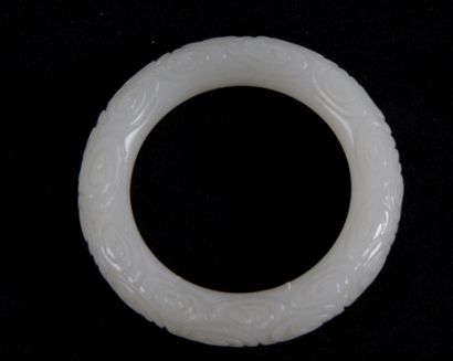  CHINA, XXth CENTURY White jade bracelet decorated with stylized spirals in light...