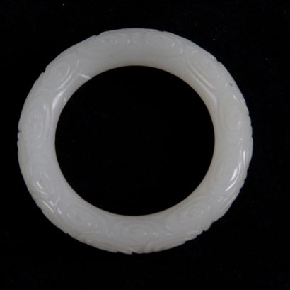  CHINE, XXE SIÈCLE Bracelet jonc en jade blanc à décor en léger relief de spirales...