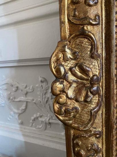 null FRONTIER MIRROR in molded, carved and openwork gilded wood decorated with foliage...