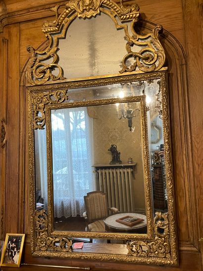 null MIRROR WITH PARECLOSES in gilded wood, molded and carved, the pediment with...