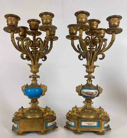 null A bronze and gilded metal CHESTLACE, including a clock and a pair of candelabras...