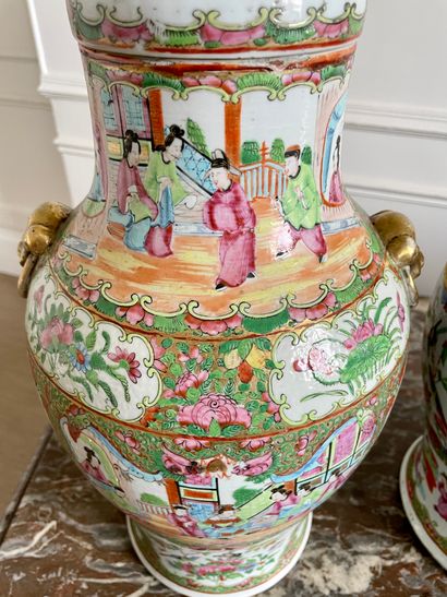 CHINA Pair of Canton enameled porcelain covered vases decorated with palace scenes...