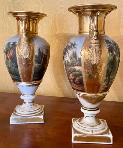 null PARIS A pair of white and gold porcelain vases on a pedestal with polychrome...