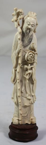 JAPON Statuette en ivoire figurant un sage portant un sceptre et une rose Fin du...