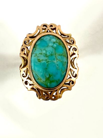 null RING holding a turquoise cabochon in a setting decorated with interlacing. Mounted...
