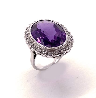 null RING holding an oval synthetic corundum of approximately 10 carats in a surround...