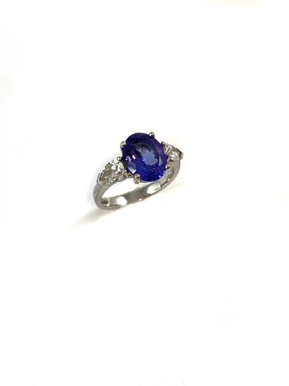 null RING holding an oval tanzanite of 2.30 carats approximately shouldered by two...