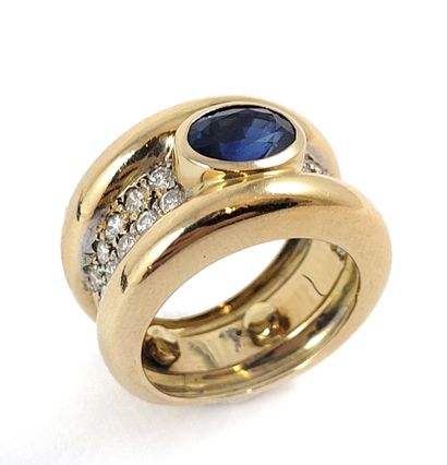 null RING adorned with three gadroons, the main one holding an oval sapphire set...