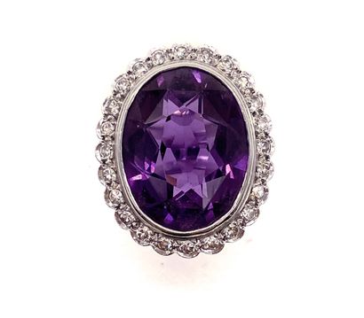 null RING holding an oval synthetic corundum of approximately 10 carats in a surround...