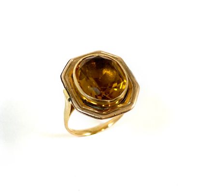 null RING holding a yellow stone probably being a citrine (closed bottom) in a closed...