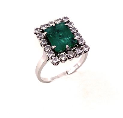 RING set with a rectangular cut emerald weighing...