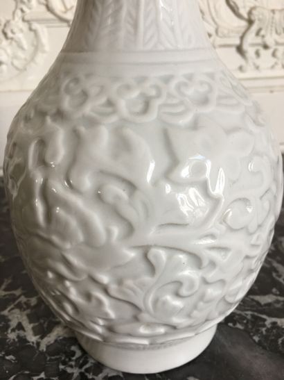 null CHINA White porcelain vase of baluster form with peony decoration in light relief....