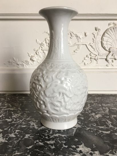 null CHINA White porcelain vase of baluster form with peony decoration in light relief....