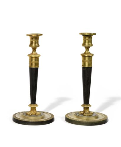 null PAIR OF FLAMPS in patinated and gilded bronze, the binnacles rest on facetted...
