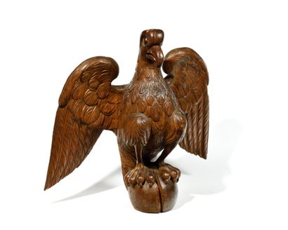 null IMPORTANT EAGLE in carved walnut with spread wings and resting on a sphere....