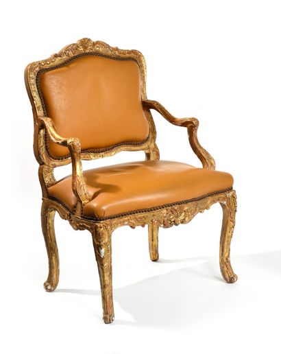null ARMCHAIR IN CARVED WOOD AND GILDED ALL FACE. The flat back, the sinuous armrests,...