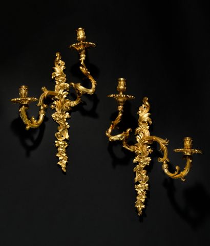 null PAIRE D’APPLIQUES en bronze doré à deux bras de lumière et décor de feuillages...
