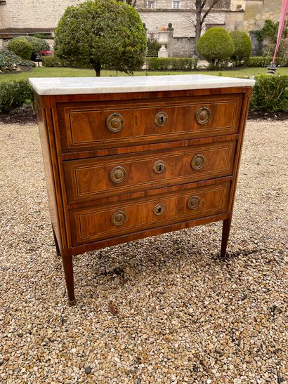 A veneer and marquetry chest of drawers opening...